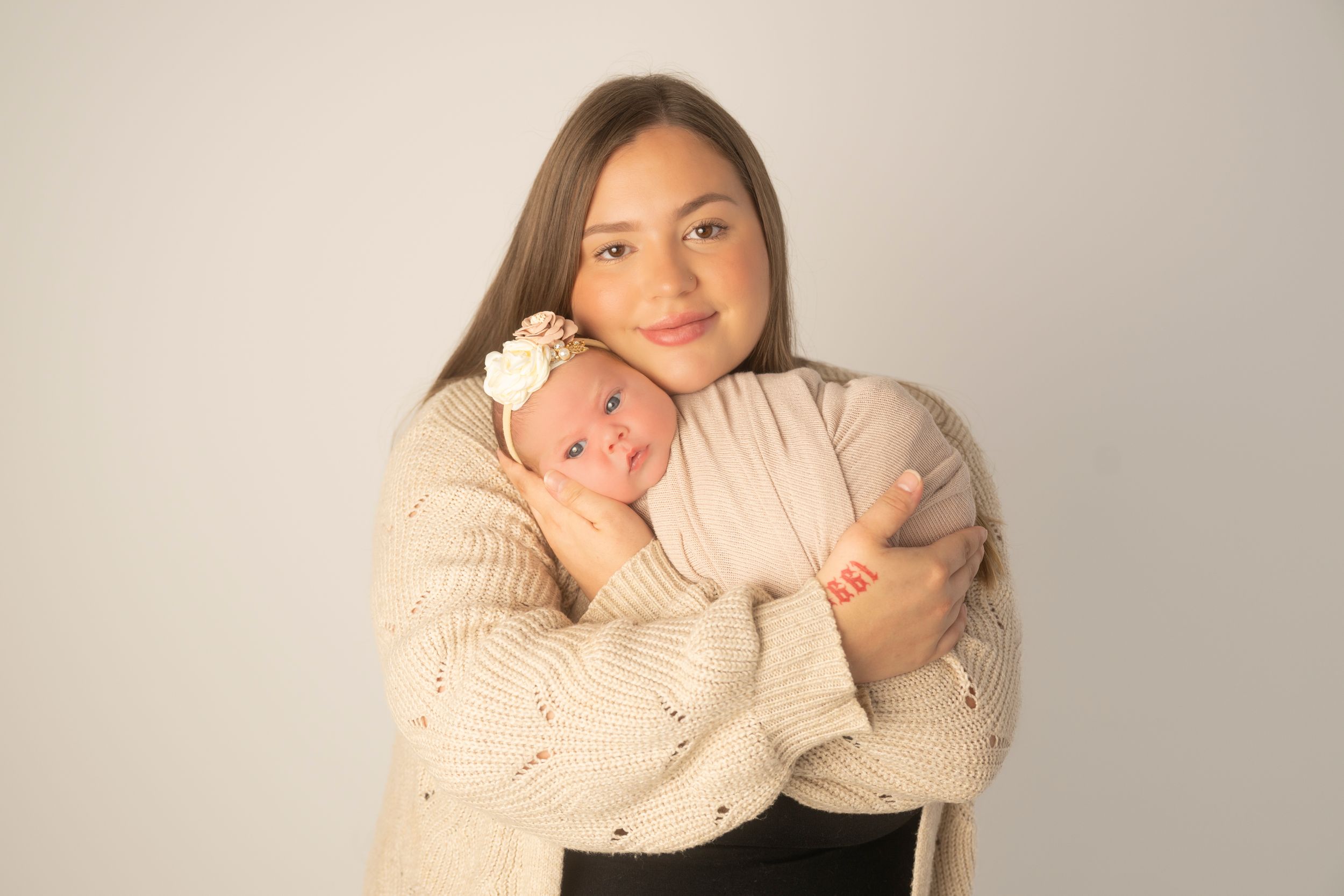 A series of four connected photos showing tender moments between parent and newborn baby against a light background.