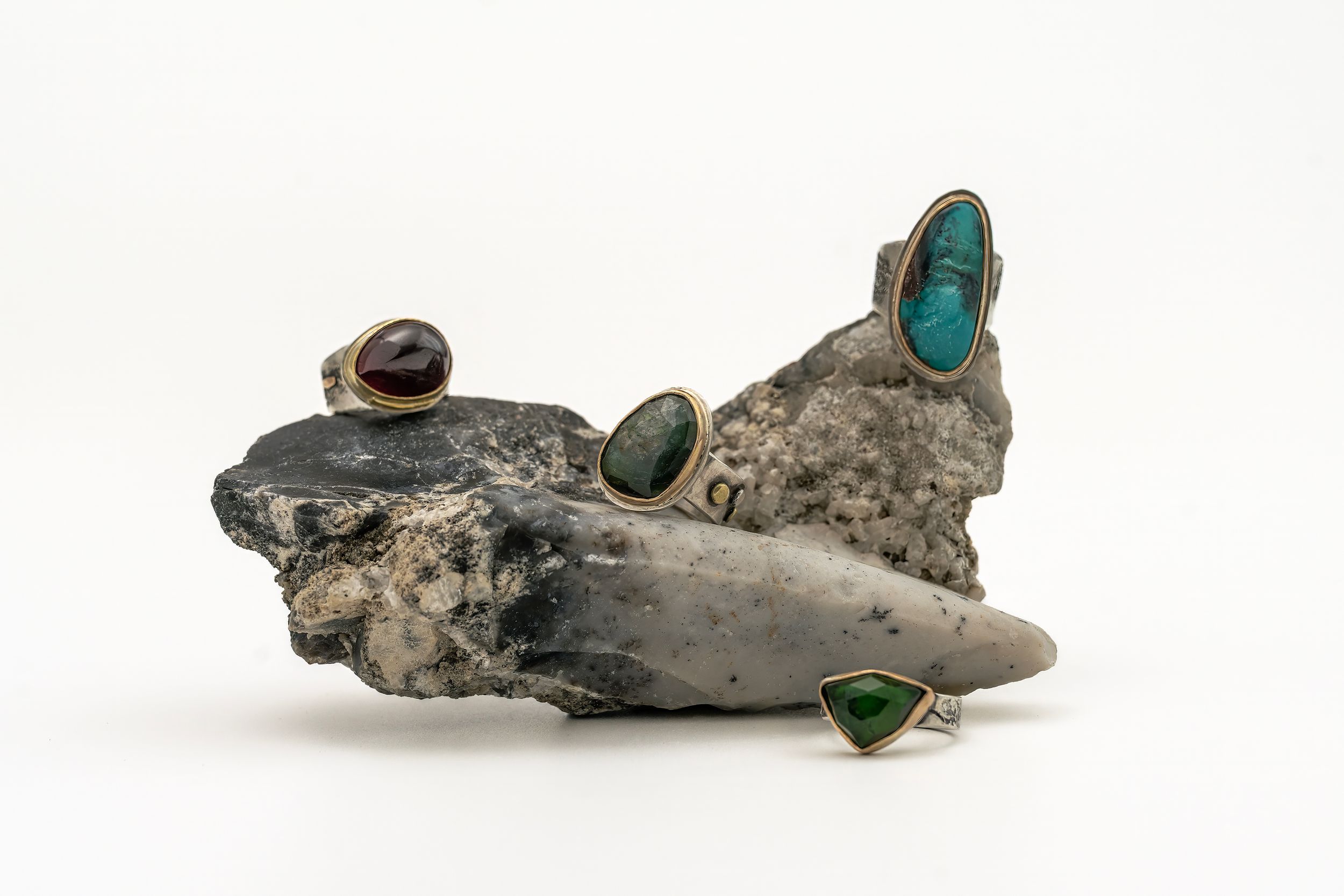A piece of driftwood decorated with small turquoise and natural stone inlays creates an artistic beach-inspired display.