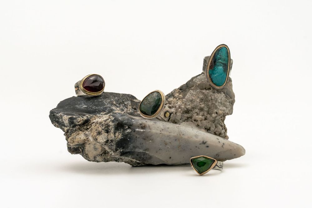 A piece of driftwood decorated with small turquoise and natural stone inlays creates an artistic beach-inspired display.