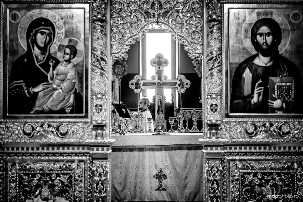 Black and white photograph of an ornate church iconostasis with religious icons and intricate decorative patterns.