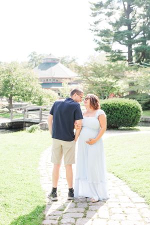 A couple walking away from the camera on a stone path through a lush garden setting, captured in three similar angles.