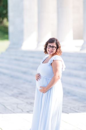 Joyful moments captured in an outdoor photoshoot featuring white columns and natural lighting.