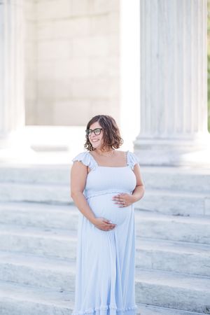 A series of four ethereal portraits in a pale blue dress against white marble columns creating a dreamy mood.