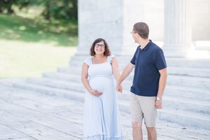 A couple wearing navy and white outfits poses together on stone steps during an outdoor photo session.