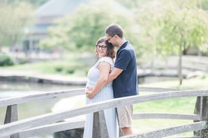 A couple shares intimate moments in front of wooden fences during an outdoor engagement photo session.