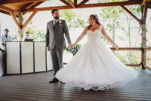 Wedding couple sharing intimate moments under a rustic wooden pavilion during their photoshoot.