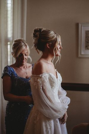 Getting ready scene with elegant white wedding dress and navy blue formal attire.