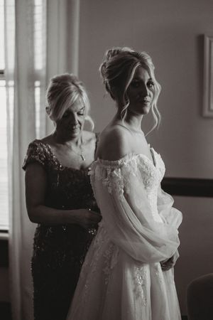 Intimate black and white photograph capturing pre-wedding preparation moments.