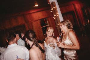 Dance floor scene at a wedding reception with red lighting and silhouettes of guests celebrating.