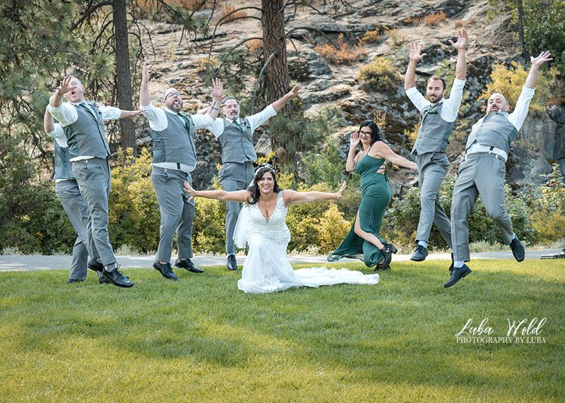 fun bridal party picture of a bride with groomsmen at Spokane wedding by photographer Luba Wold