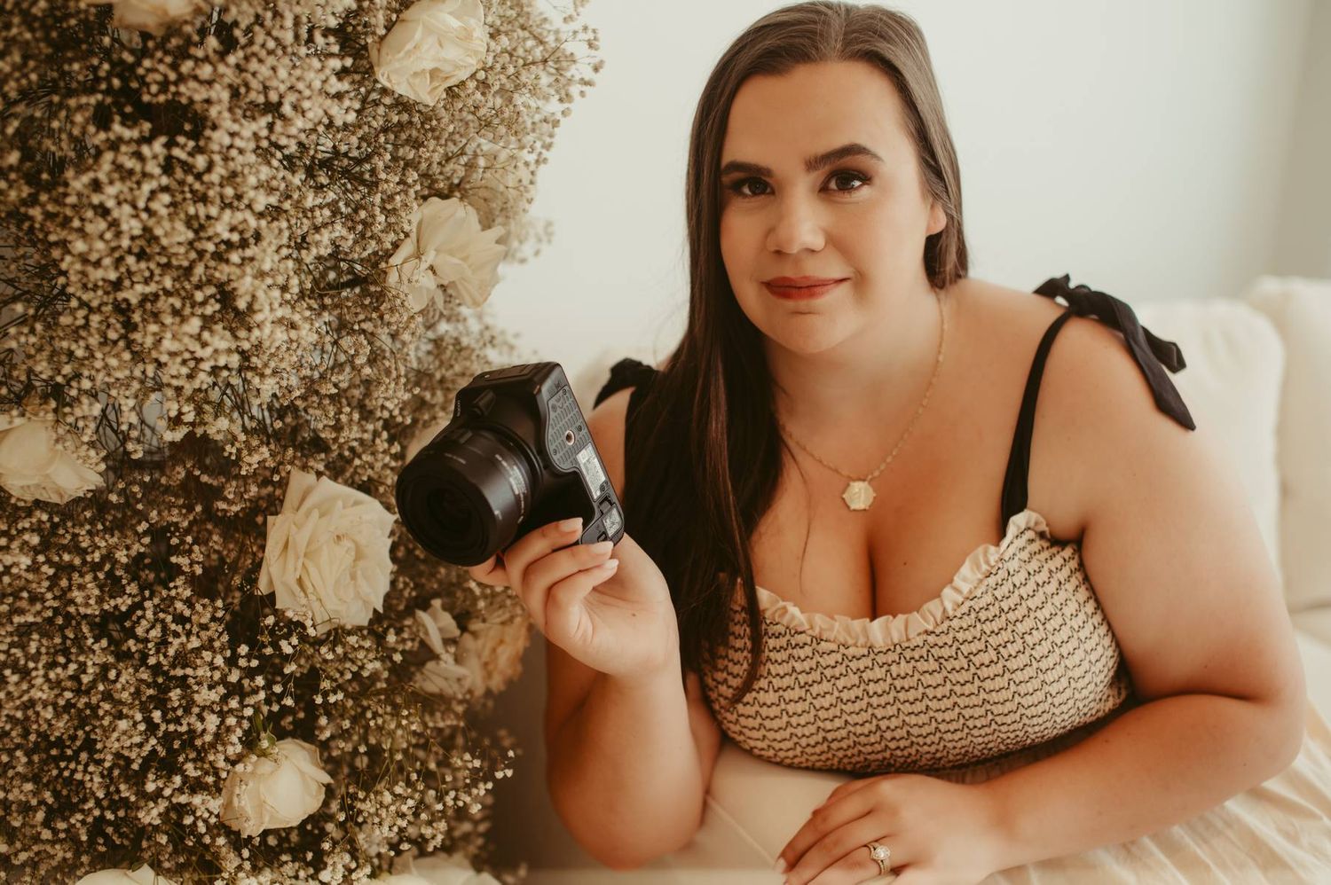 Woman in beige crochet top poses for intimate boudoir photography session.