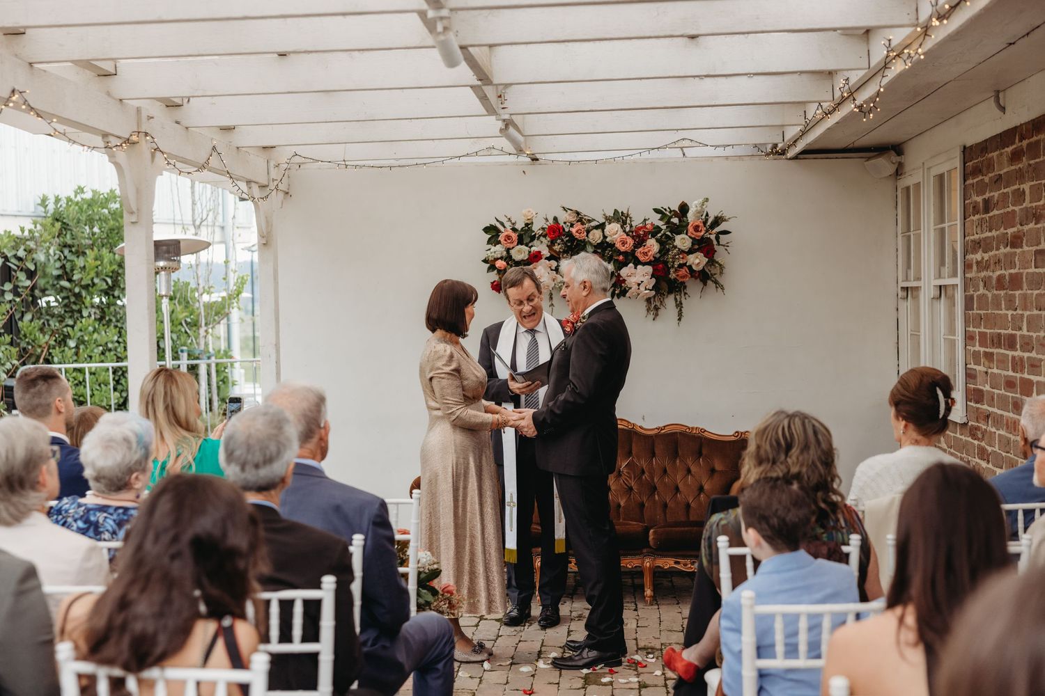 Wedding ceremony setup with white pergola and floral arch decoration.