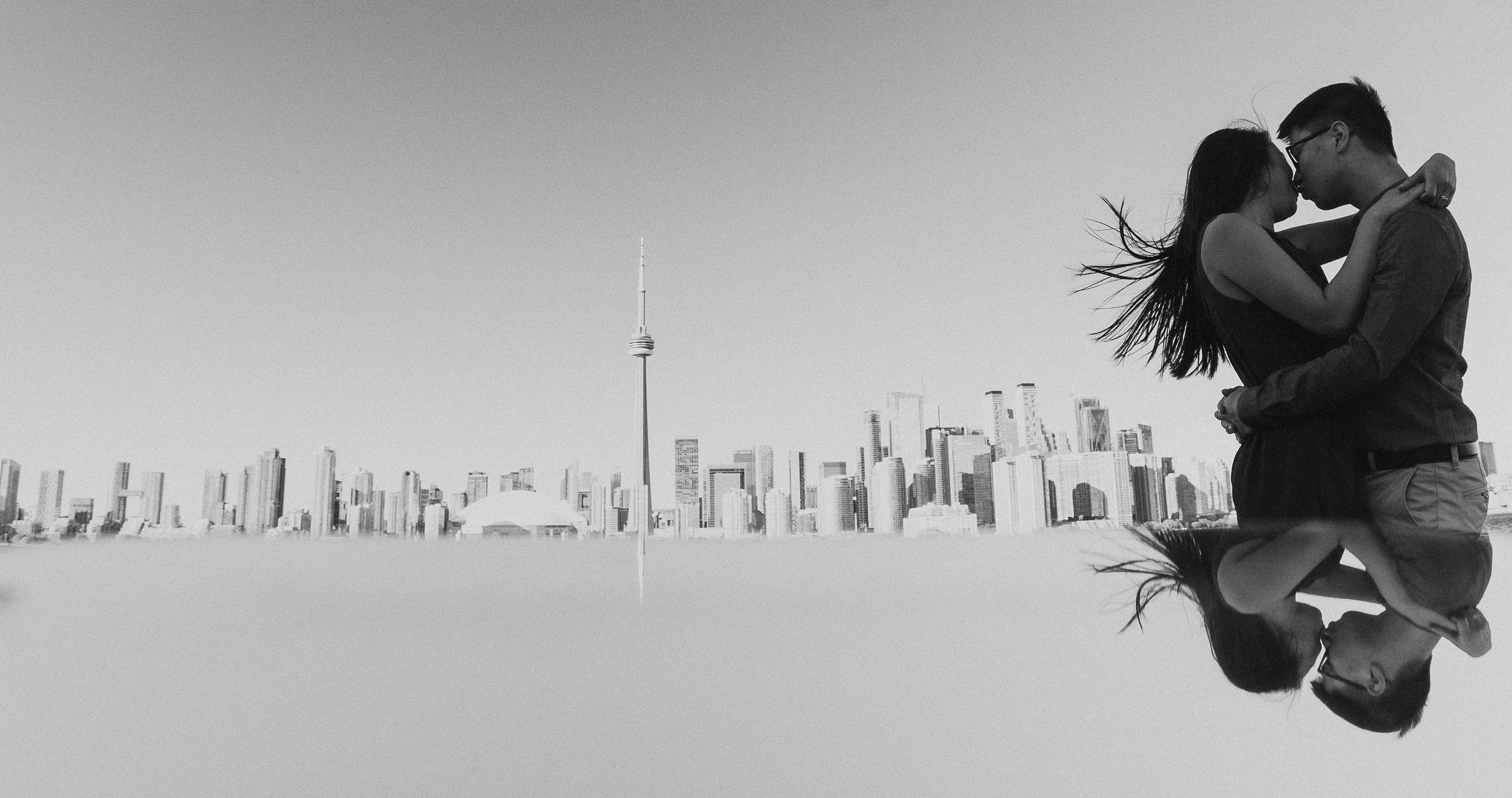 A silhouetted couple embraces against a cityscape backdrop.