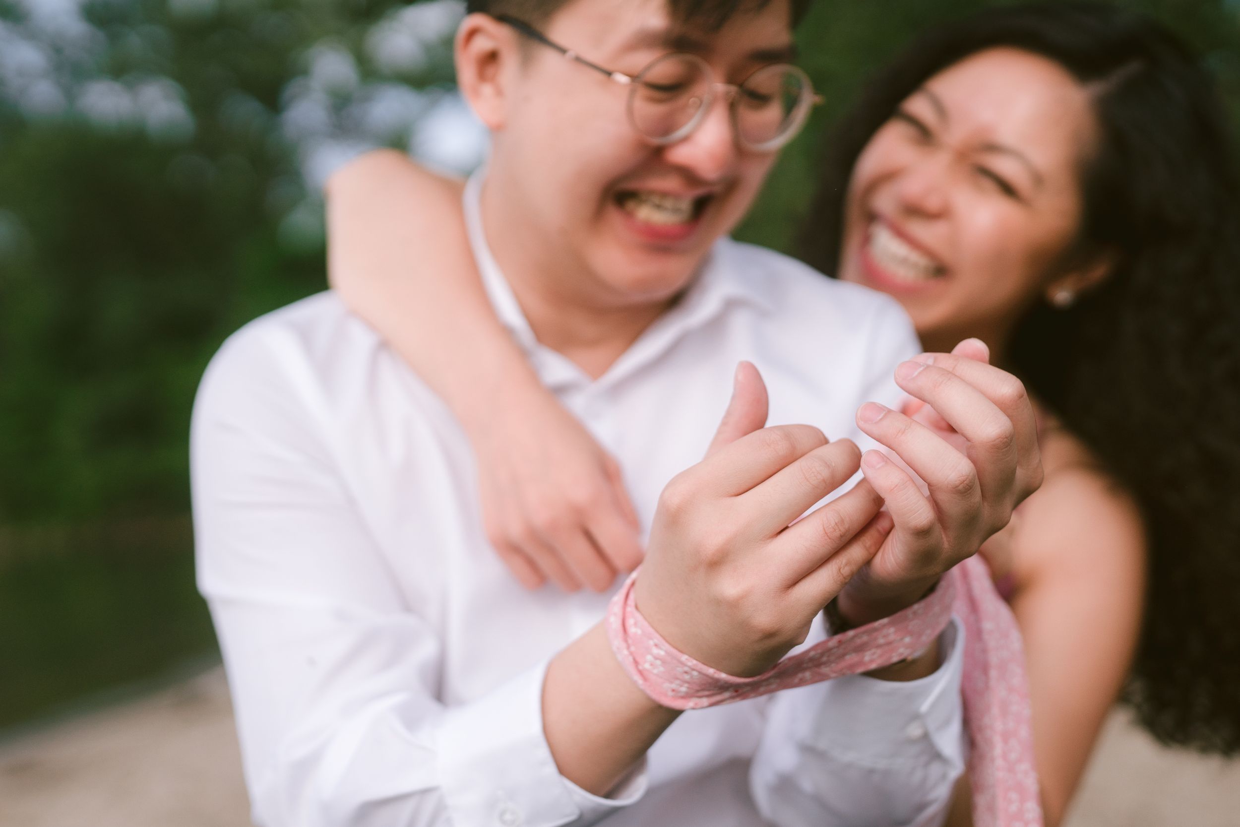A couple shares a joyful moment during their engagement photoshoot.