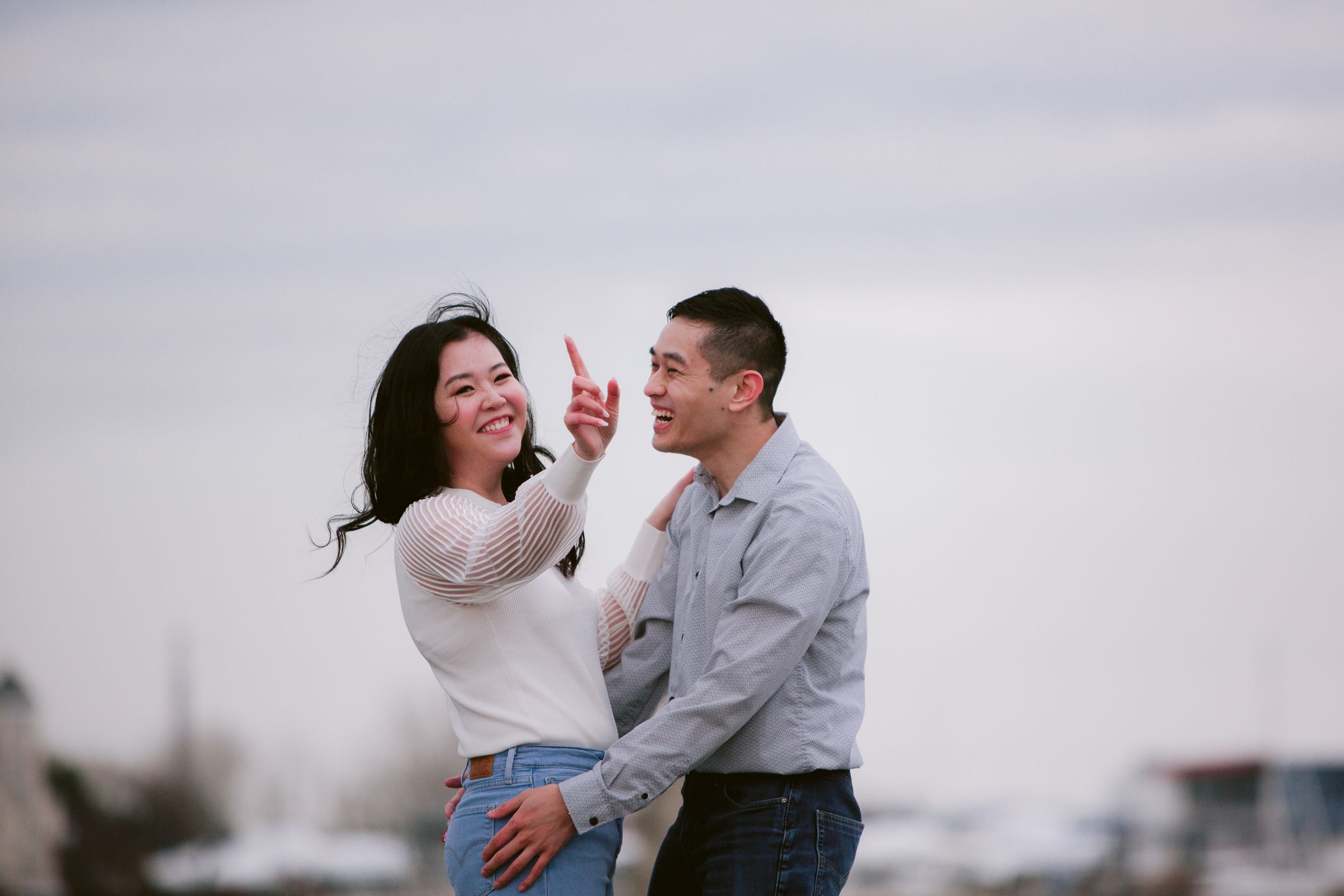 A joyful moment shared between a couple against an overcast sky.