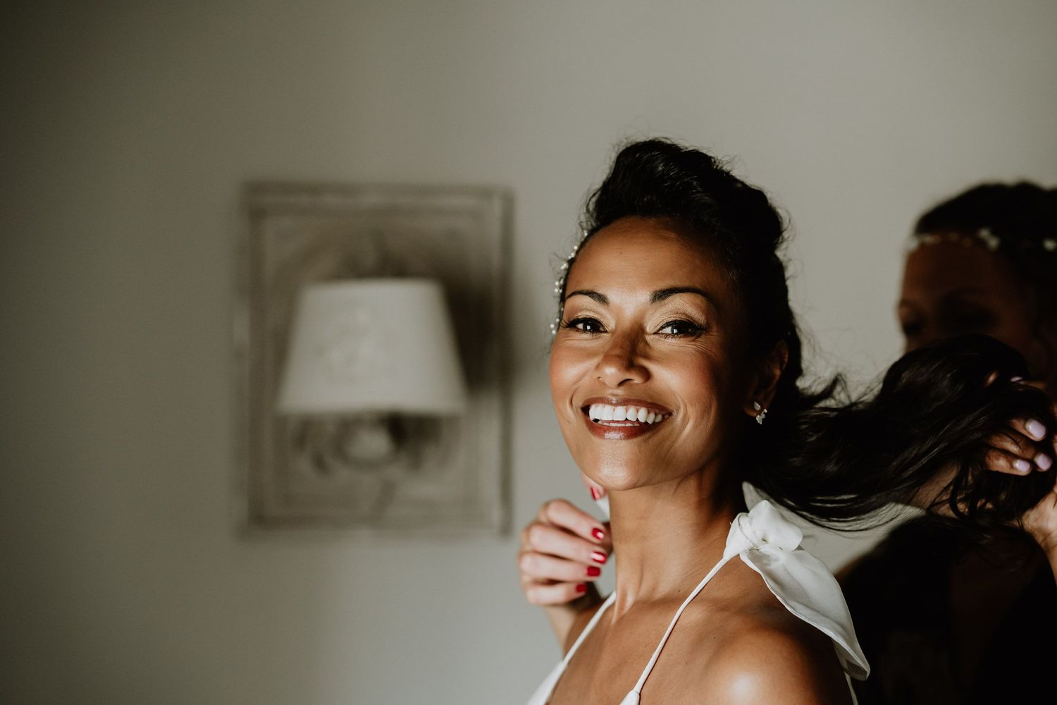 Radiant bride smiles brightly while getting ready for her wedding day.
