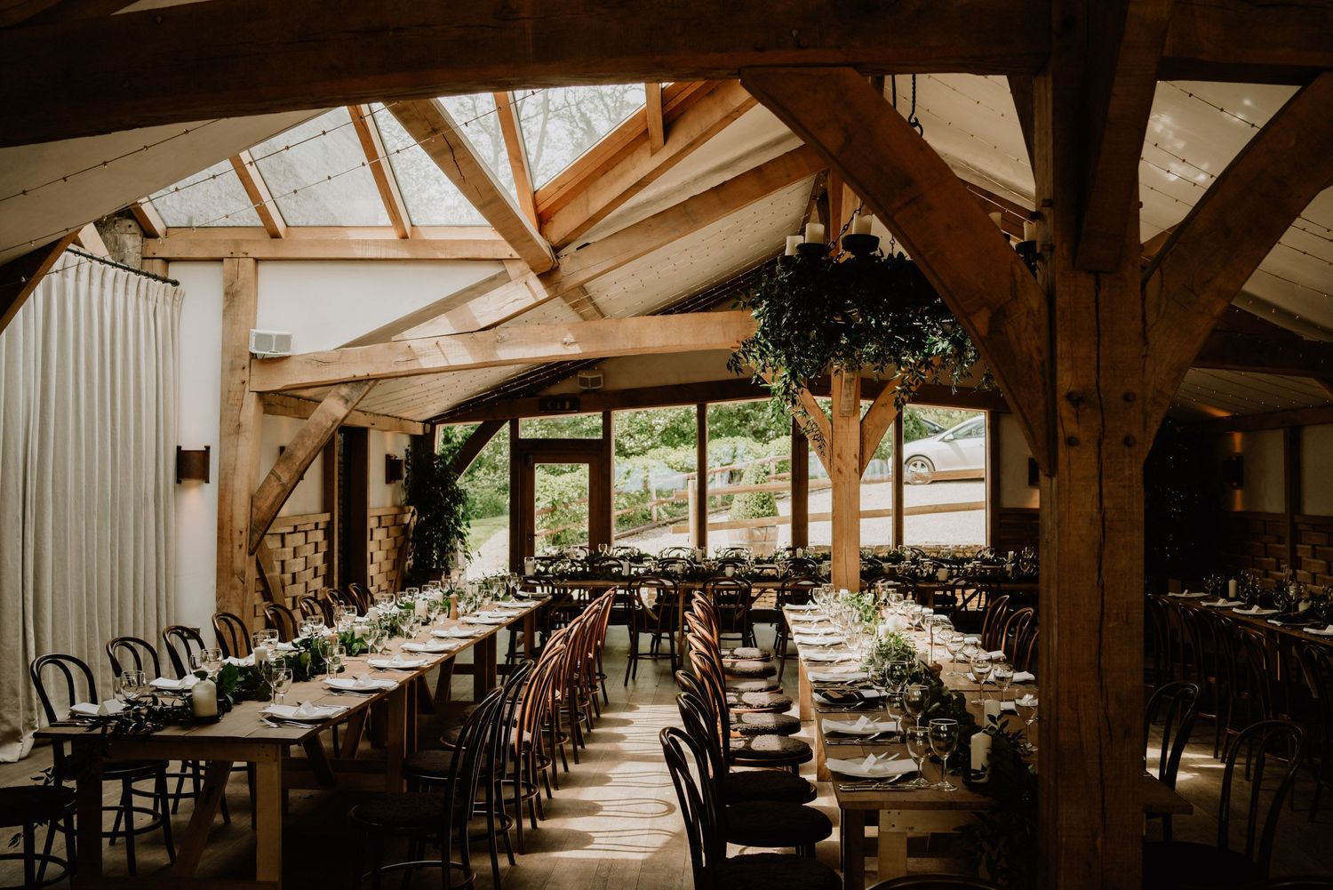 Rustic reception venue with wooden beams and elegant table settings.