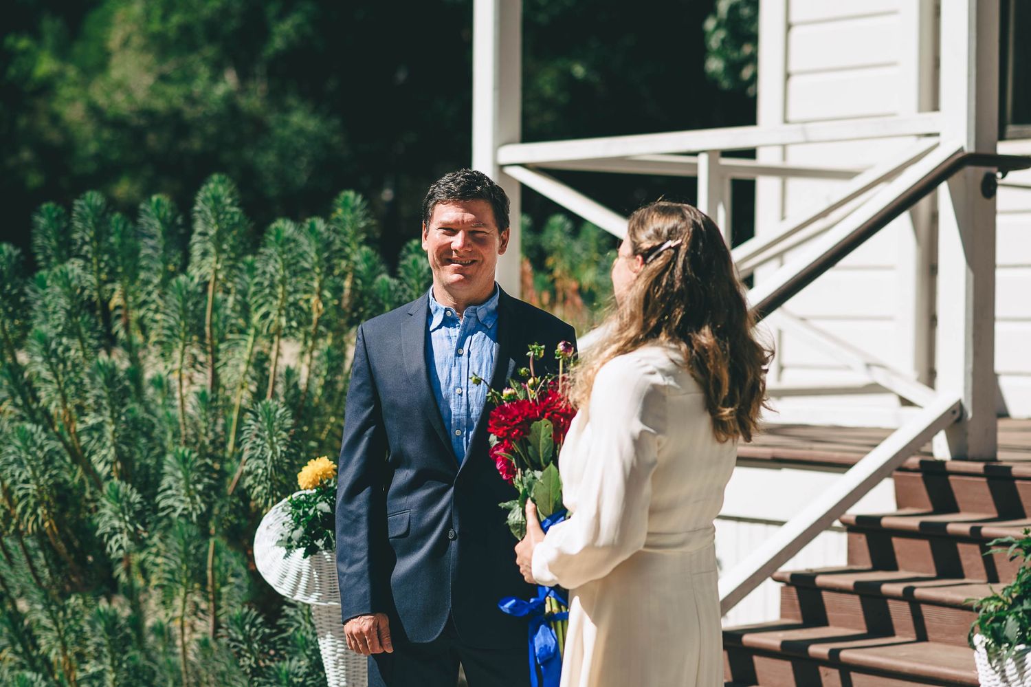 Groom in blue suit looking at bride