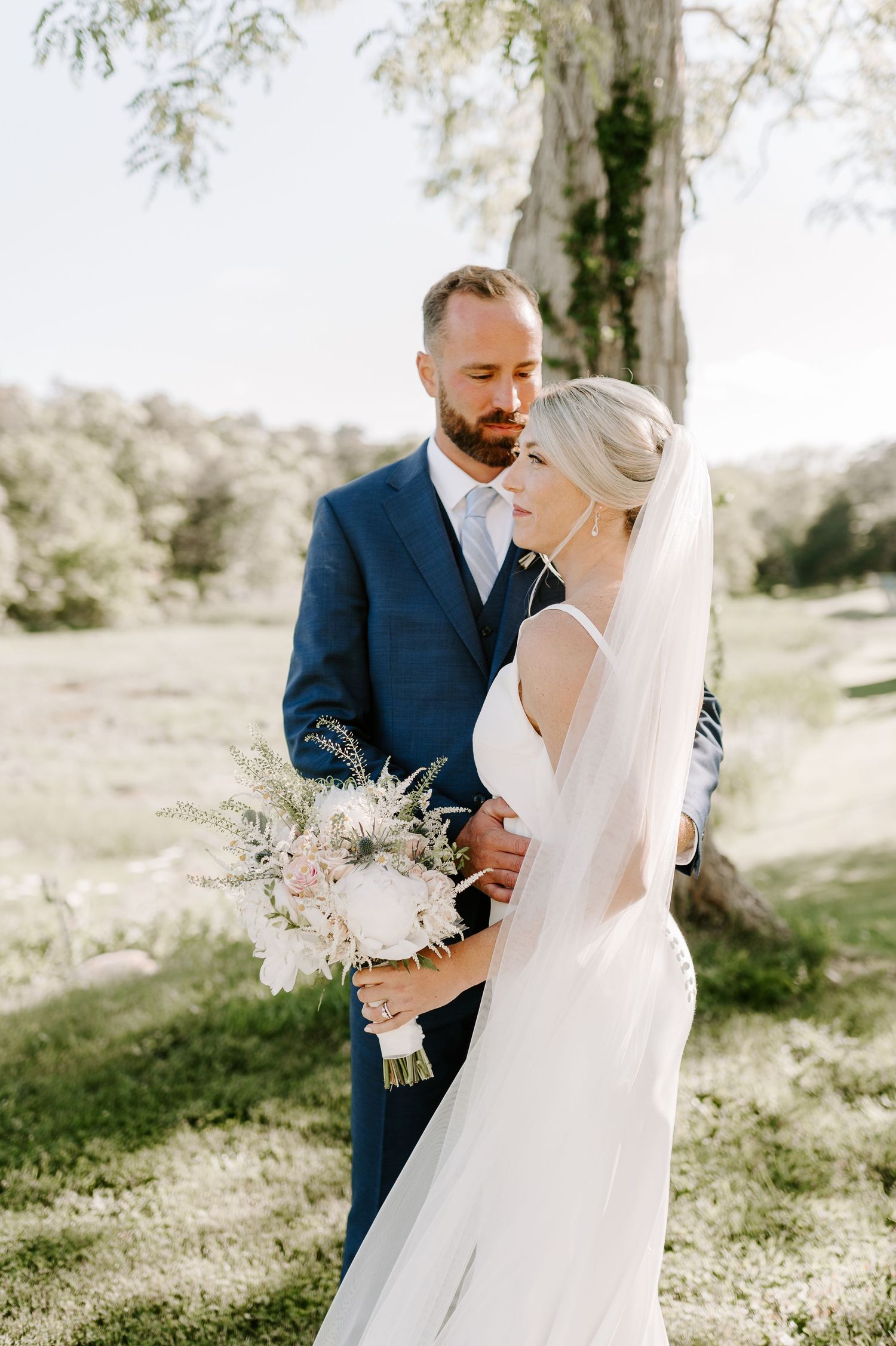 Intimate wedding moments captured in sun-drenched spring garden setting.