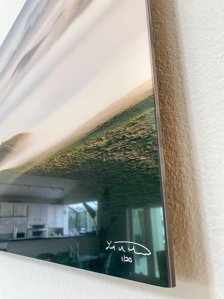 Close-up detail of canvas print corner showing signature and mounting.