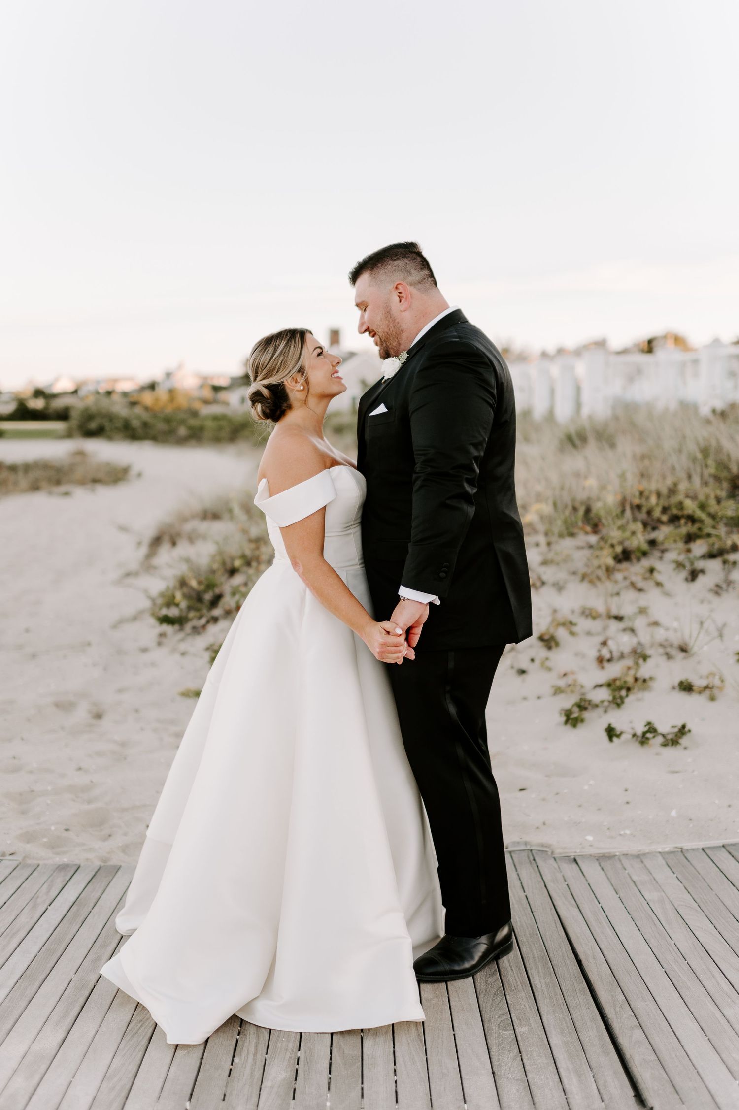 Romantic wedding portraits on a coastal boardwalk showing intimate moments between newlyweds.