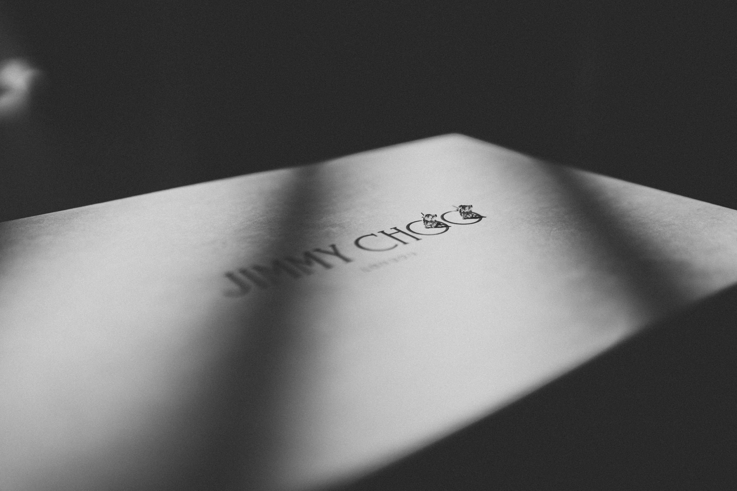 Close-up of Jimmy Choo logo text in dramatic black and white lighting.