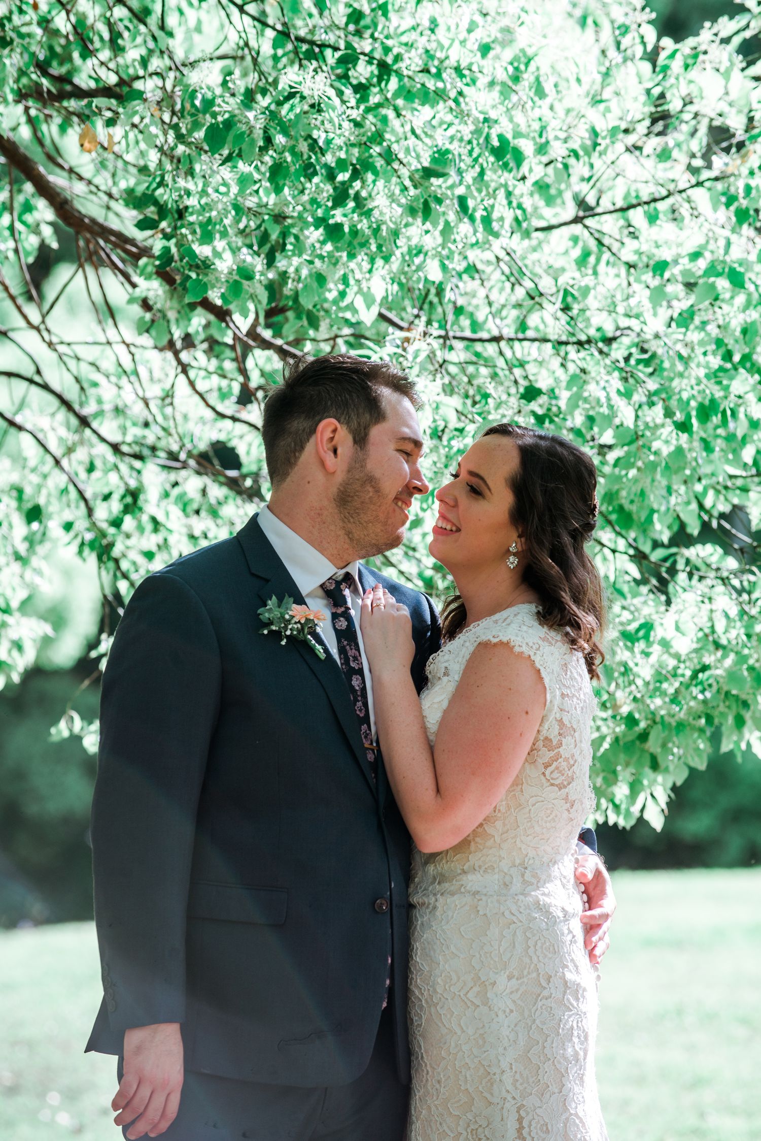 Romantic couple shares an intimate moment under spring foliage.