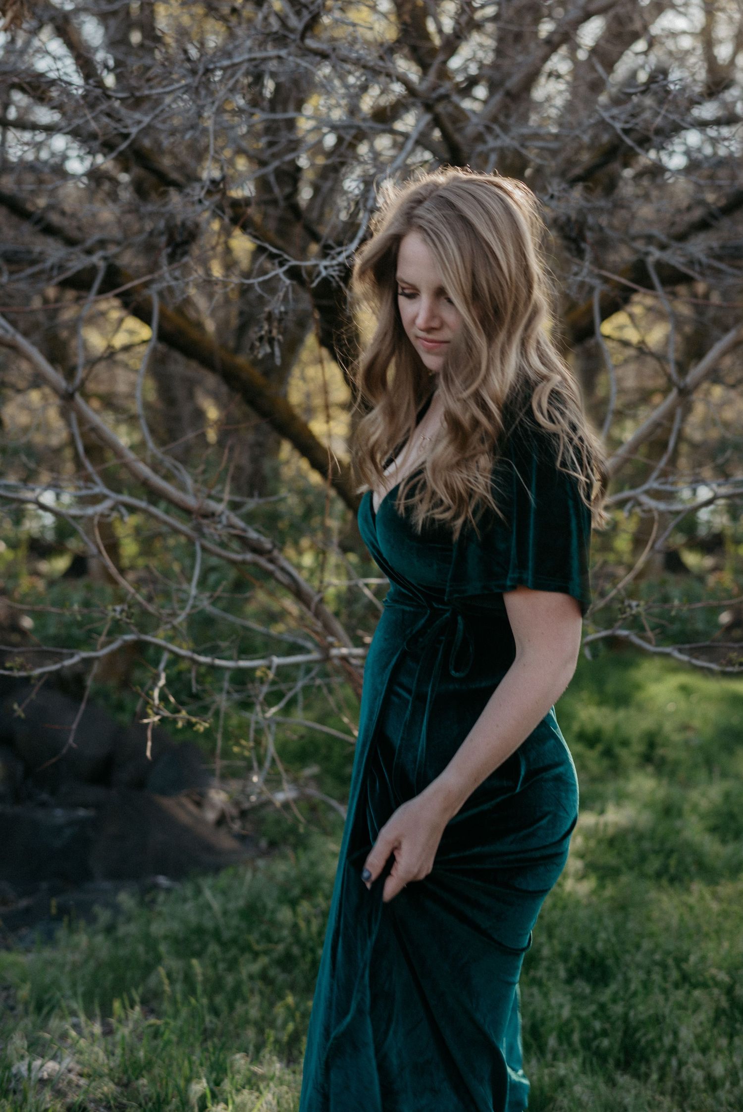 a woman looks down with a tree in the background in boise