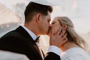 bride and groom under vail