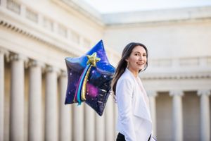 Woman wearing a white jacket and holding a star balloon at Legion of Honor