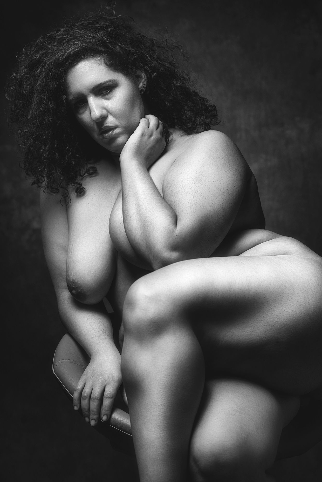 artistieke zwart wit foto van een voluptueuze dame naakt in de stoel