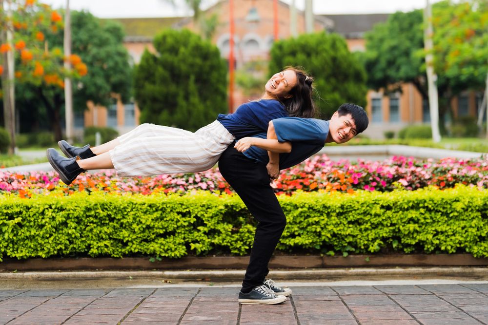 Friends demonstrate a fun balancing pose against a backdrop of tropical gardens.