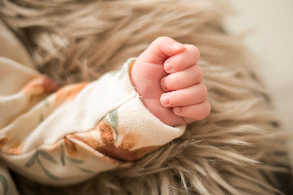 Newborn hand on rug