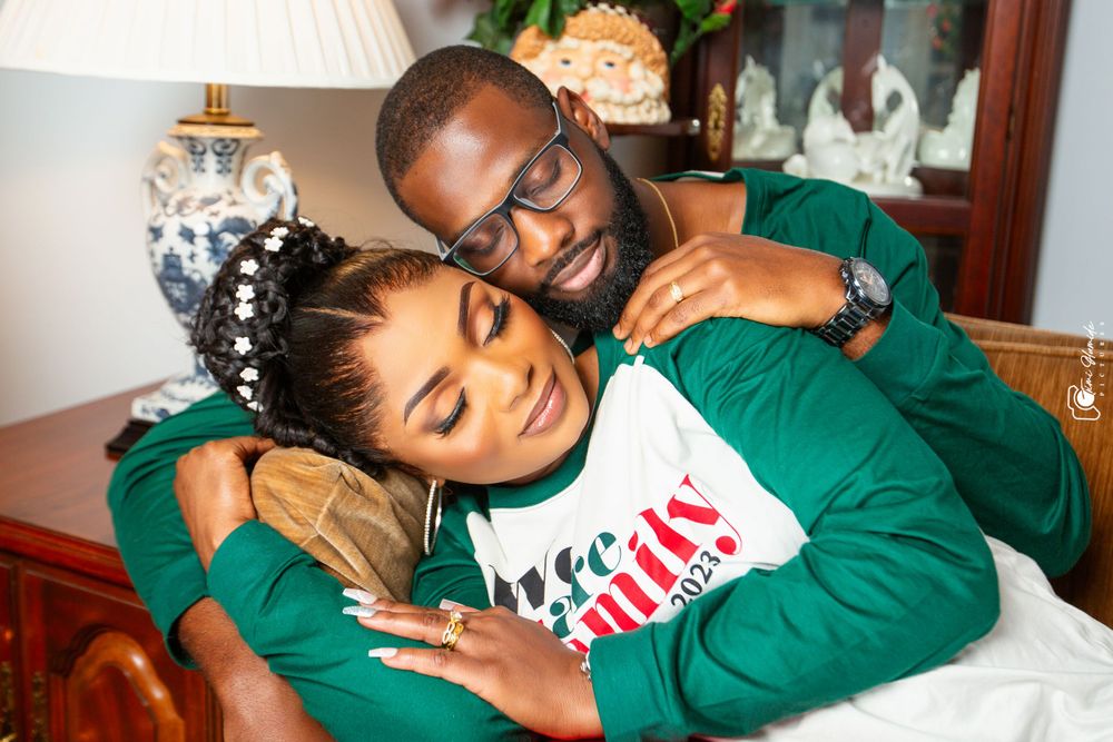 Couple in matching green hoodies cuddling on sofa.