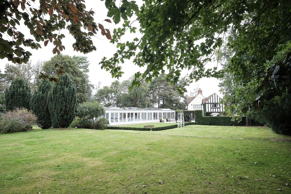 Elegant white gazebo and lawn on spacious garden estate grounds.