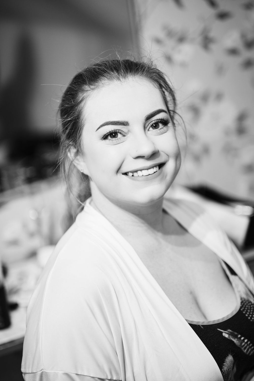 Black and white portrait of a joyful person in a white robe.