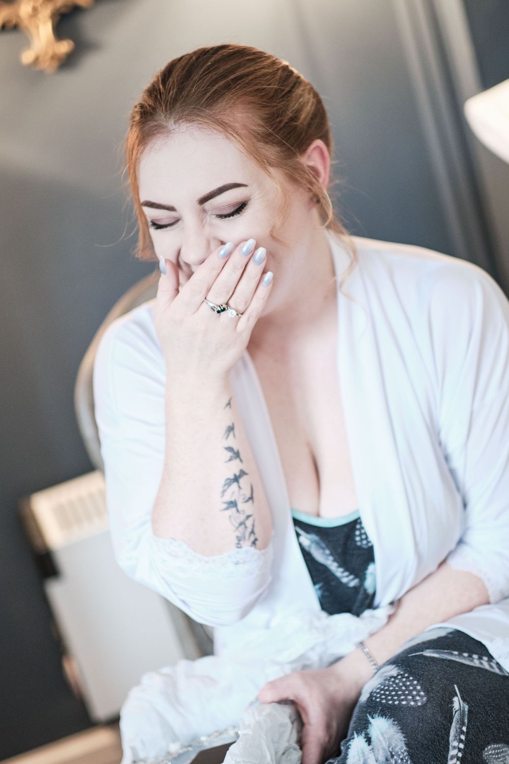 Candid moment of someone in white robe showing engagement ring.