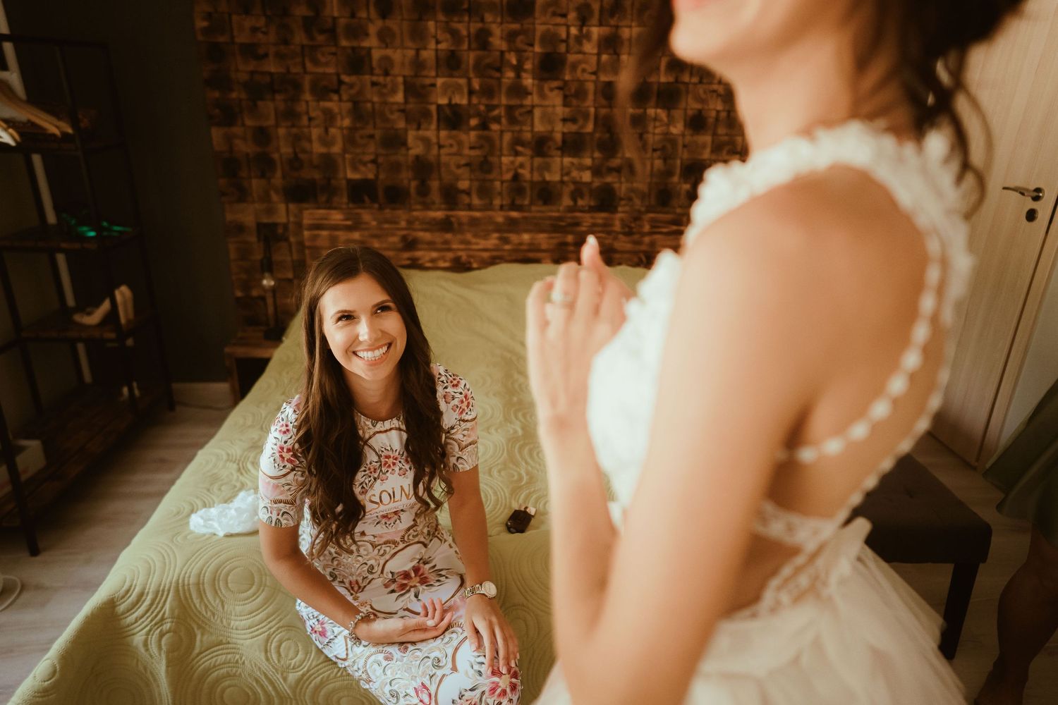 Warm-toned wedding preparation photo with decorative brown wall backdrop.