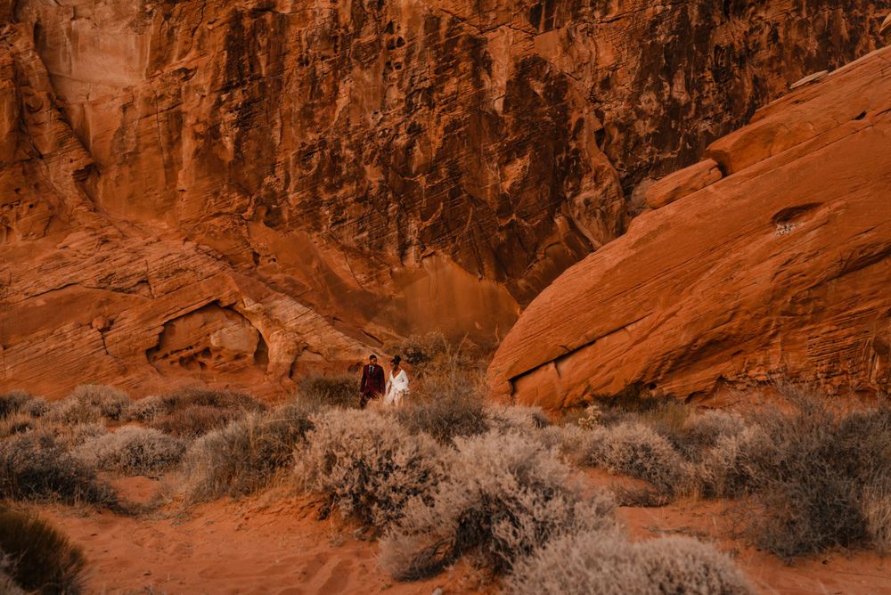 Wedding couple poses between towering red rock canyon walls.