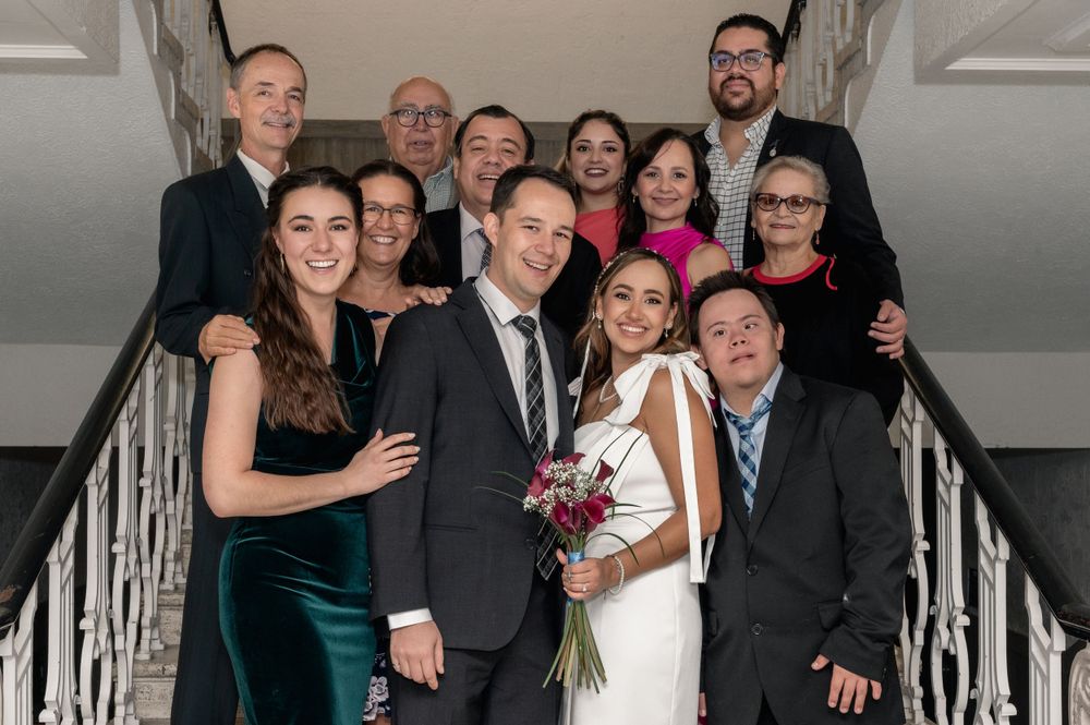 Wedding party poses on indoor staircase for casual group photo.
