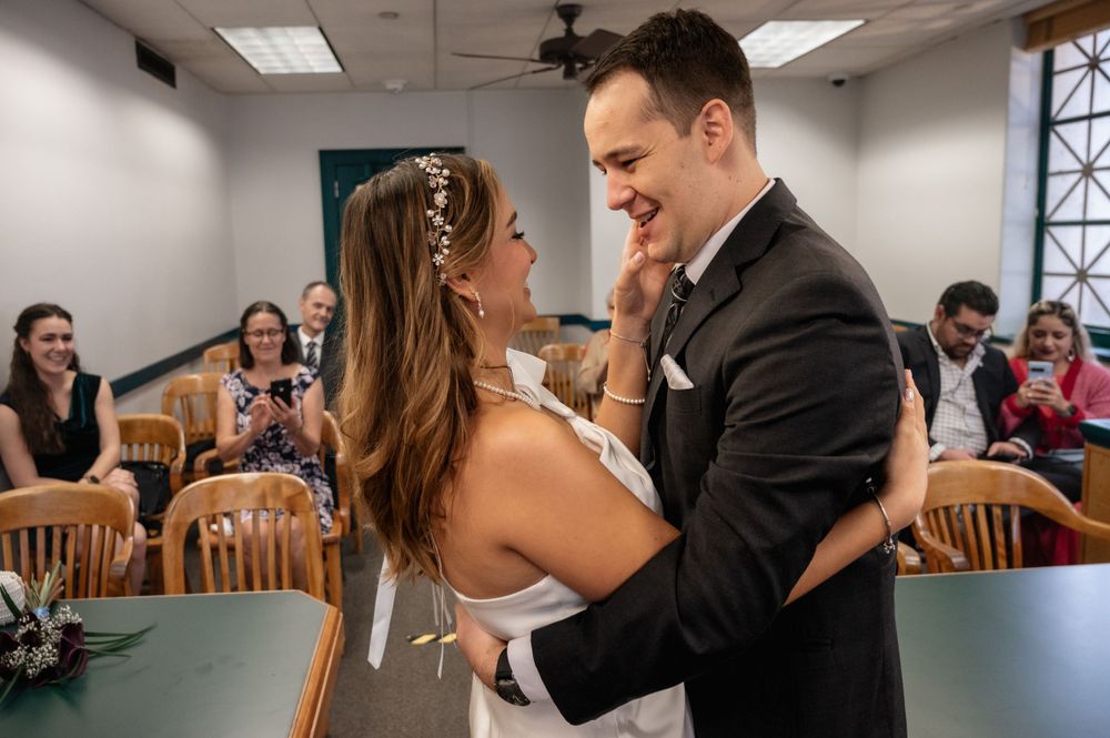A newlywed couple shares an emotional moment during their courthouse wedding ceremony.