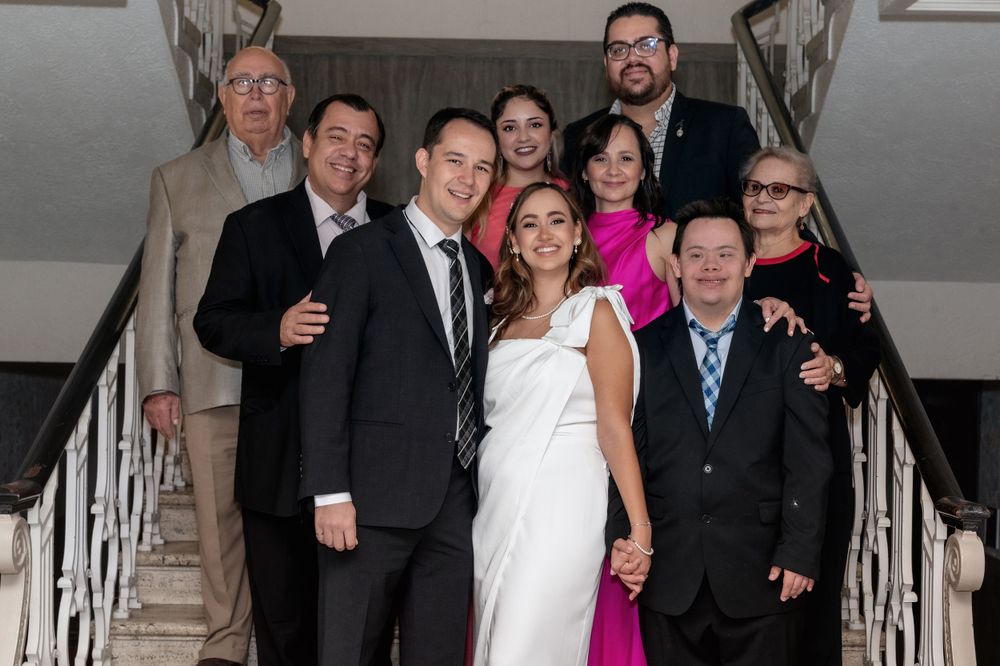 Group photo of wedding party standing on an elegant staircase.