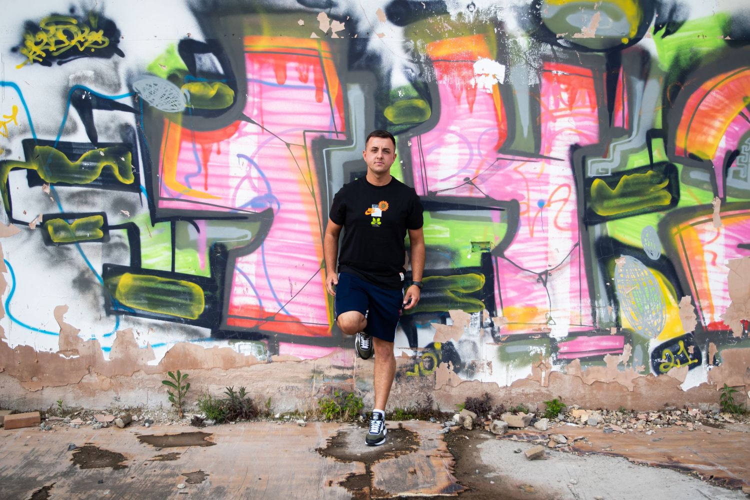 Young man leant against a graffiti wall for business headshot by photographer in Doncaster