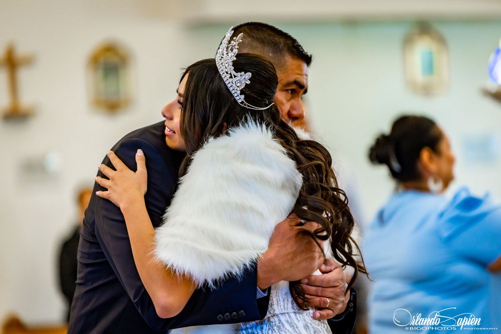 People embracing during an emotional celebration in a church setting.