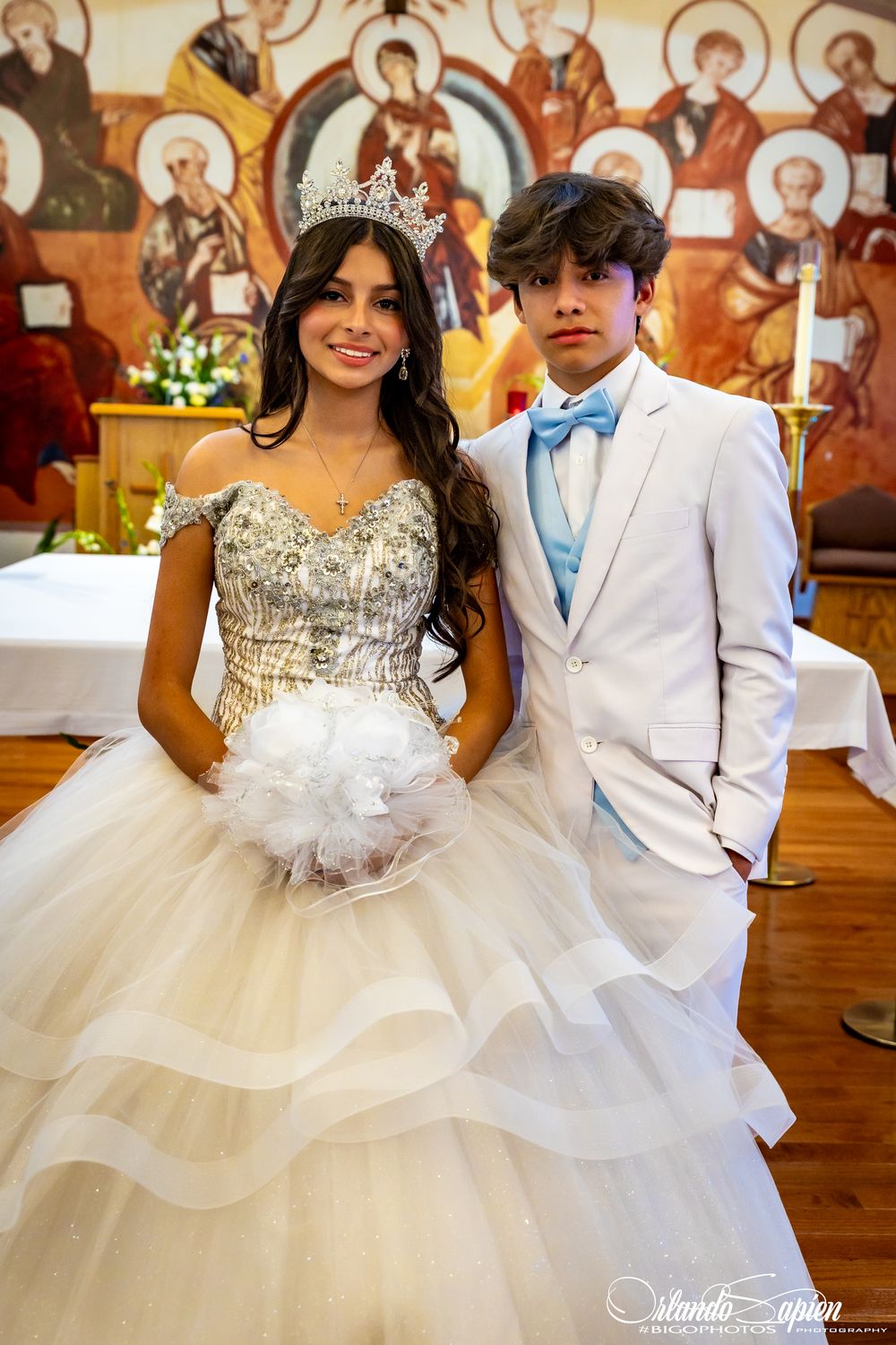 A celebration featuring elegant white gowns and formal attire against a decorative church backdrop.