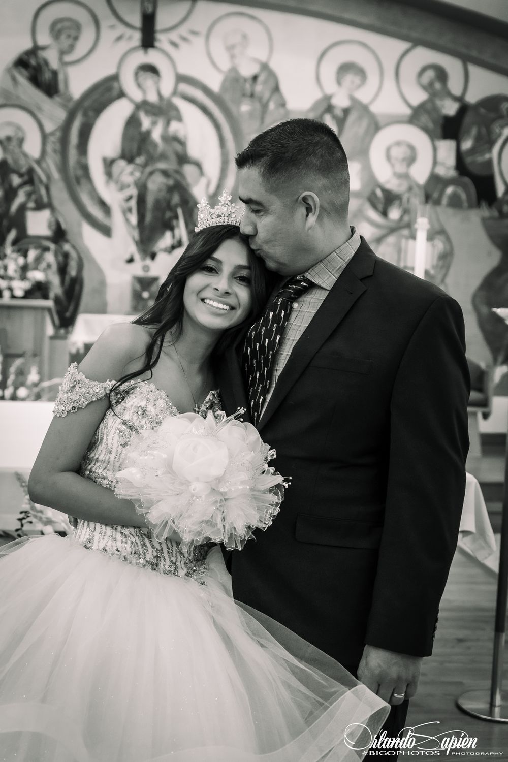 Black and white photo of a tender moment during a formal celebration in church.