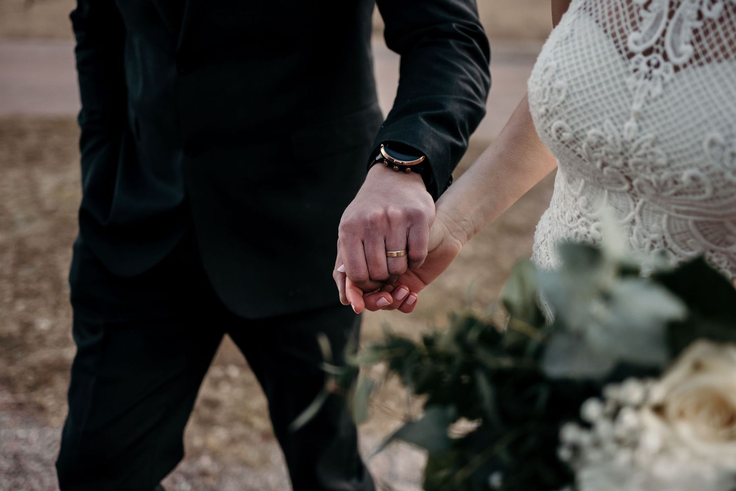Close-up shot of formal wedding attire and floral arrangements in an outdoor setting.