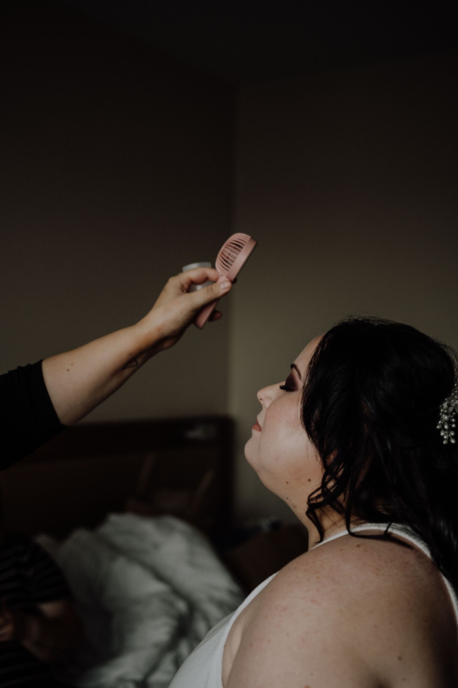 Artistic shot of makeup being applied with a brush during wedding preparations.