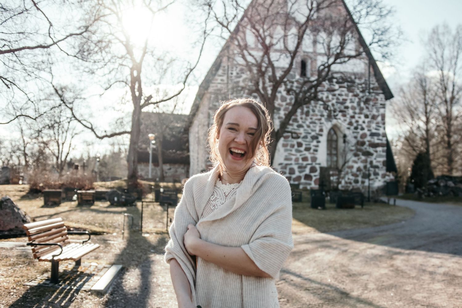 Joyful moment captured outside a historic stone church on a sunny day.