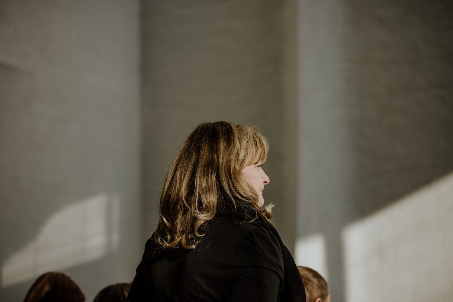 Side profile view of person in church with dramatic lighting and shadows.